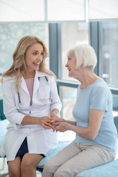 istock Long-haired cute nurse talking to an elderly patient 1280005188