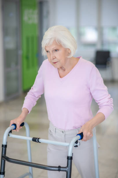 istock Elderly woman walking with a rolling-walker 1280005300