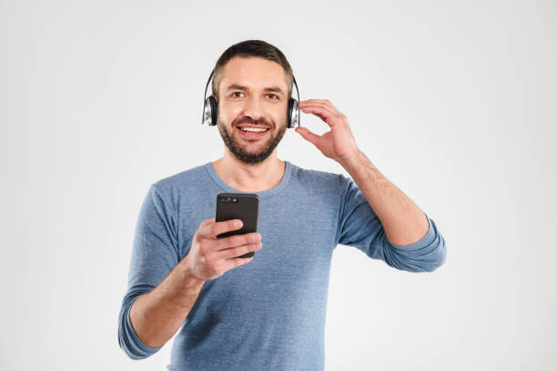 istock Cheerful man listening music using mobile phone. 1280005677