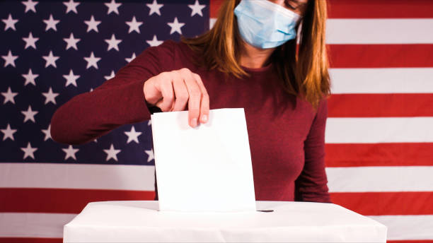 istock Woman with face mask voting 1280006796