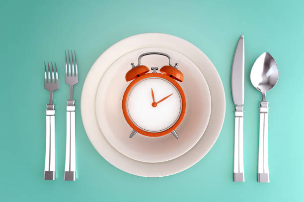 istock Alarm clock on plate set, concept for intermittent fasting diet and schedule of meal for weight loss. 1280006978