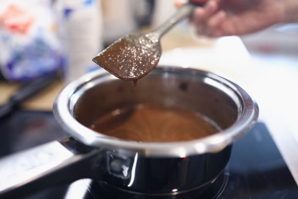 istock Female hand hold spoon close up and mix cream in kitchen. 1280009943