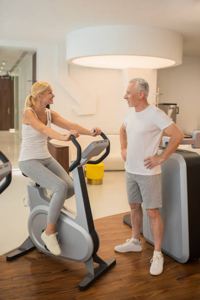istock Woman on a treadmill talking to her male instructor 1280012432