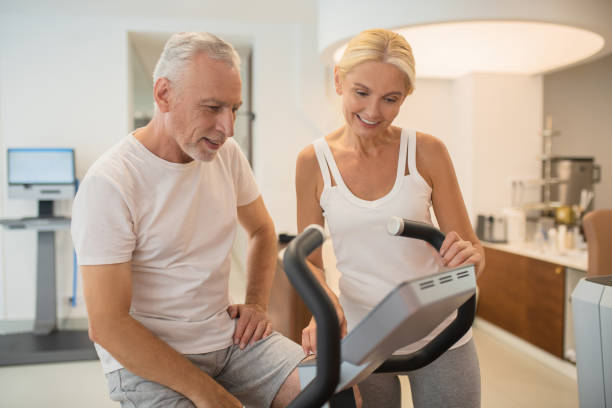 istock Man on a treadmill and his female instructor looking involved 1280012444