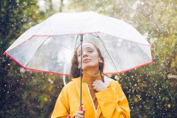 istock Joyful woman walking in rainy weather 1280013055