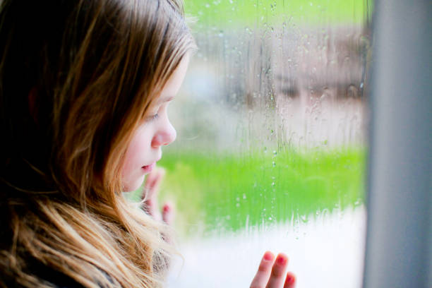 istock Sad little girl looking out the window 1280013759