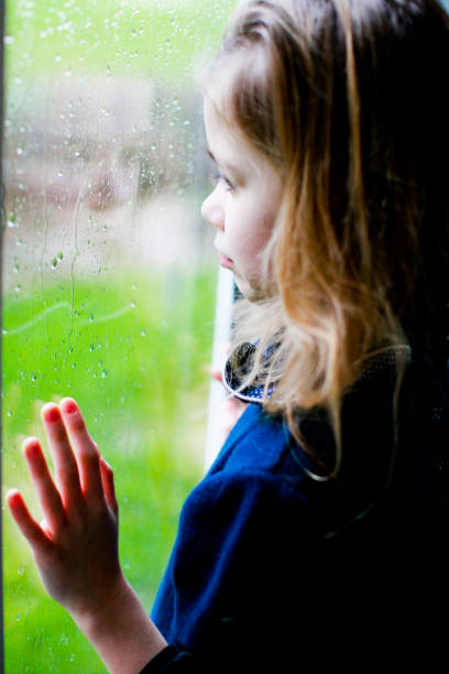 istock Sad little girl looking out the window 1280013784