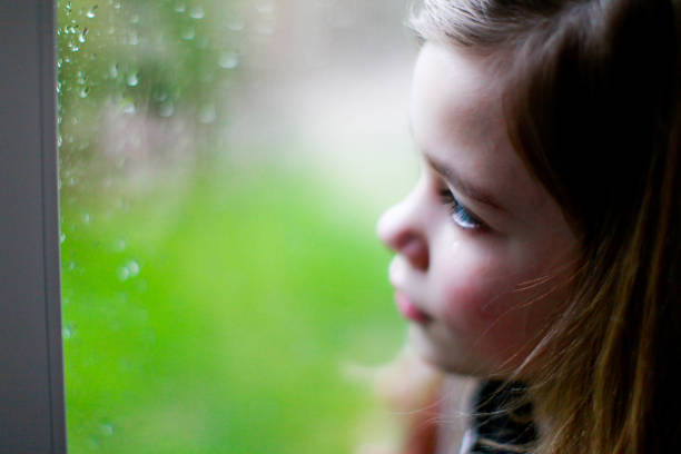 istock Sad little girl looking out the window 1280013831