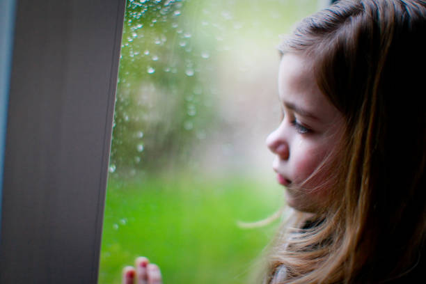 istock Sad little girl looking out the window 1280013842