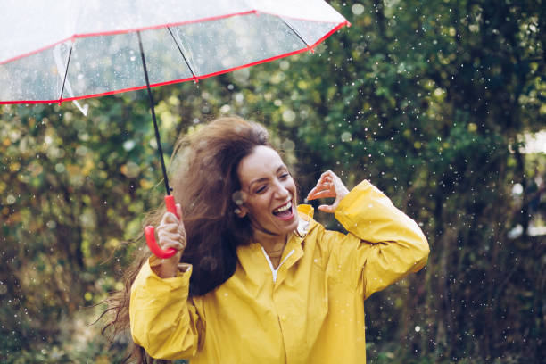 istock Joyful woman walking in rainy weather 1280013882