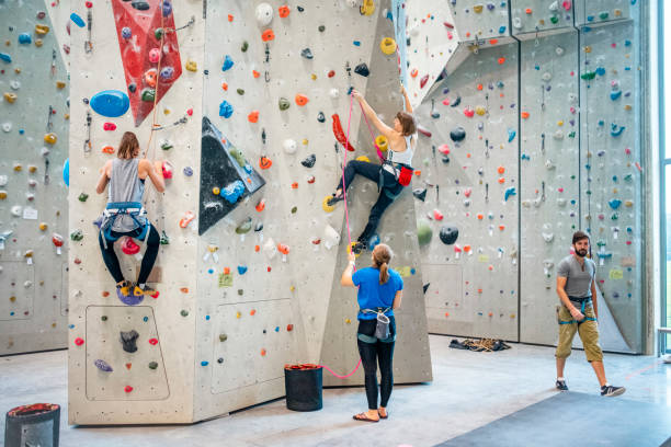 istock Mixed Age Range Sportswomen Climbing and Belaying in Gym 1280014151