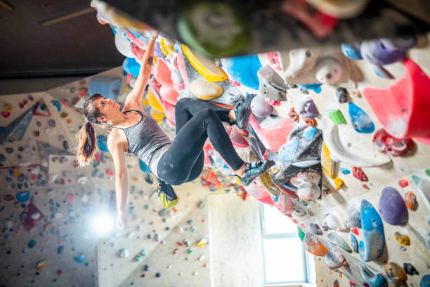 istock Female Climber Scaling Boulder Wall Without Rope and Harness 1280014224