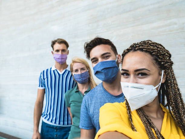 istock Happy multiracial friends taking a selfie while wearing protective face mask - Coronavrius lifestyle 1280015285