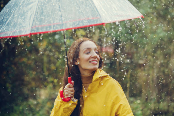 istock Happy girl standing outside during rain 1280015617