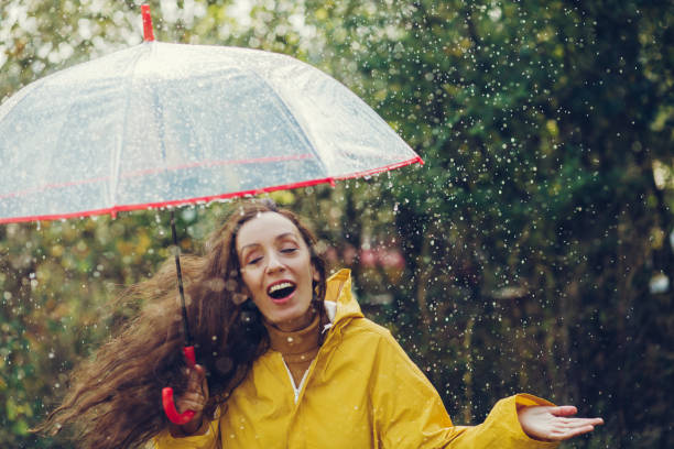 istock Happy girl standing outside during rain 1280015710