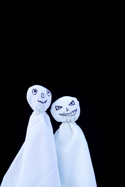 istock Decoration for Halloween. Two ghost figures on black background. Handmade decor for party. 1280015754