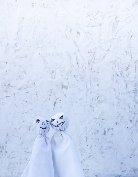 istock Decoration for Halloween. Two ghost figures on light background. Handmade decor for party. 1280015797