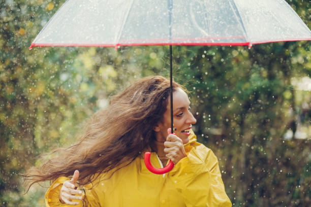 istock Happy girl standing outside during rain 1280015956