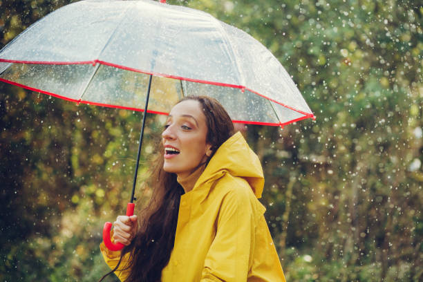 istock Happy girl standing outside during rain 1280015957