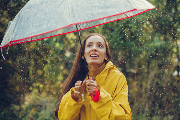 istock Happy girl standing outside during rain 1280016001