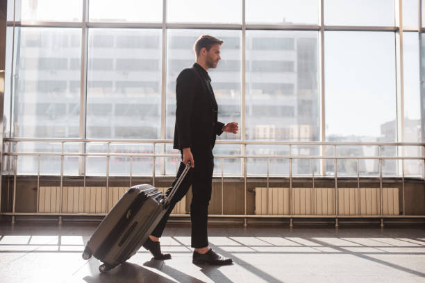 istock Man walking through the airport with his suitcase 1280016896