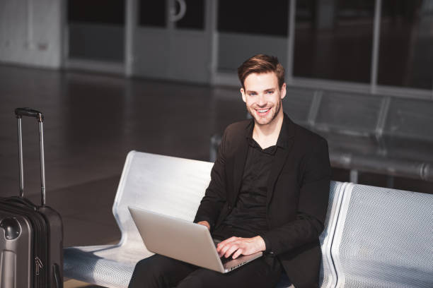 istock Smiling man working with the computer in the airport 1280016939