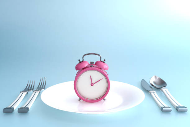 istock Alarm clock on plate set, concept for intermittent fasting diet and schedule of meal for weight loss. 1280017250