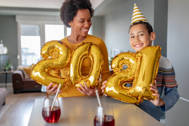 mutter und sohn feiern ney-jahr 2021 zu hause - balloon child people color image stock-fotos und bilder