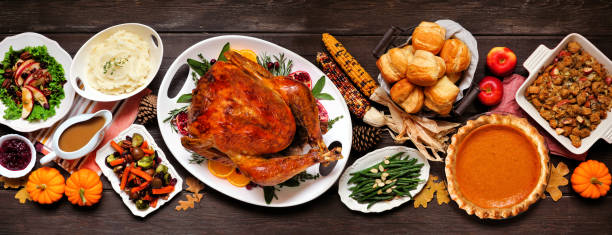 istock Traditional Thanksgiving turkey dinner. Top view table scene on a dark wood banner background. 1280020962