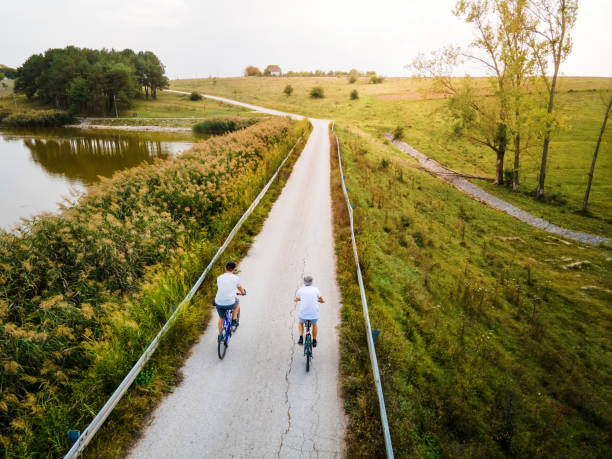 istock Men riding bicycle in the nature outdoors aerial top view 1280022814