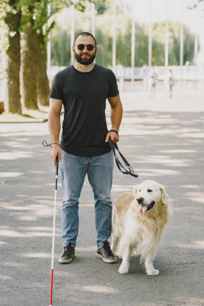 istock Blind man with guide dog in a summer city 1280022981