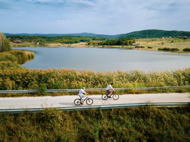 istock Men riding bicycle in the nature outdoors aerial top view 1280022982