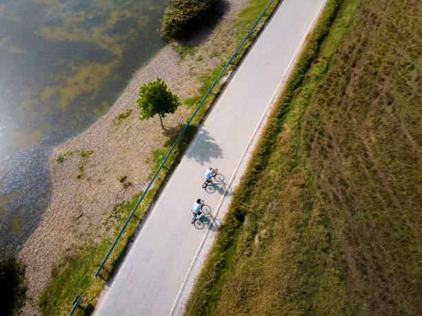 istock Men riding bicycle in the nature outdoors aerial top view 1280023102