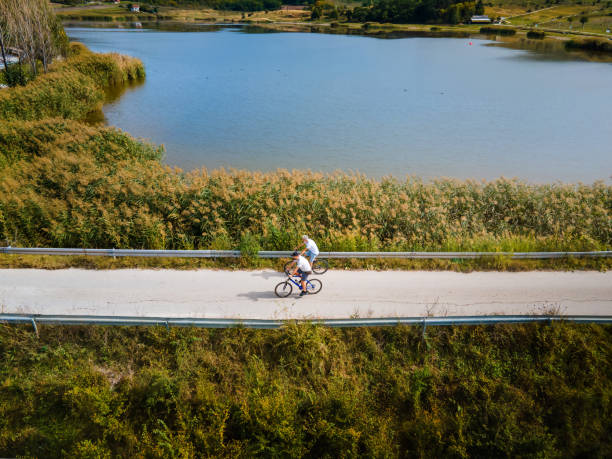 istock Men riding bicycle in the nature outdoors aerial top view 1280023169