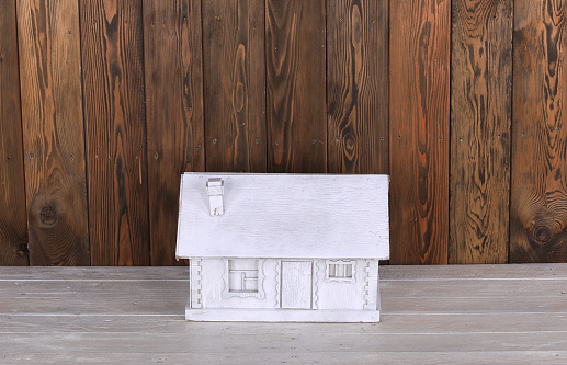 model of white wooden village house on wooden background