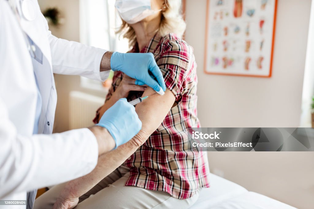 Prevention is better than cure Vaccines for the Elderly. Professional Male Doctor in Blue Sterile Gloves Injecting Vaccine to Senior Woman. Vaccination, Medicine and Healthcare. Covid, Coronavirus Vaccine COVID-19 Vaccine Stock Photo