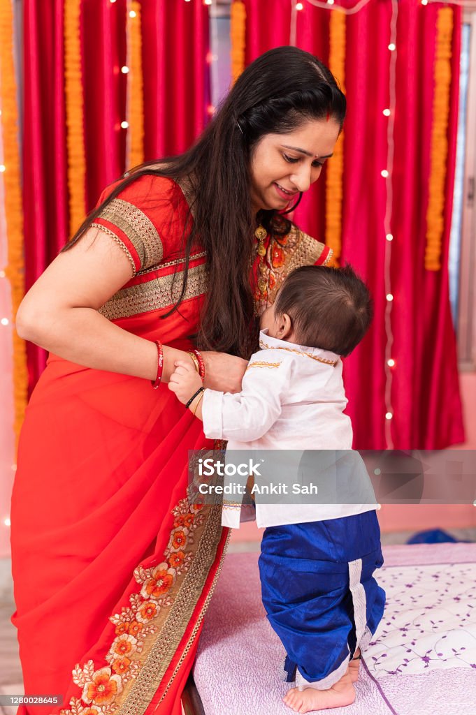 Mother changing little baby's dress Mother changing little baby's dress for Diwali celebration. Makar Sankranti Stock Photo