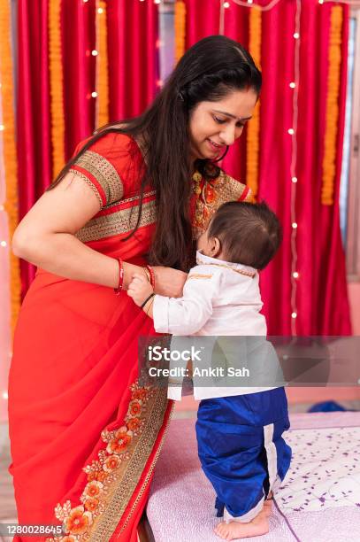 Mother Changing Little Babys Dress Stock Photo - Download Image Now - Makar Sankranti, Adult, Asian and Indian Ethnicities