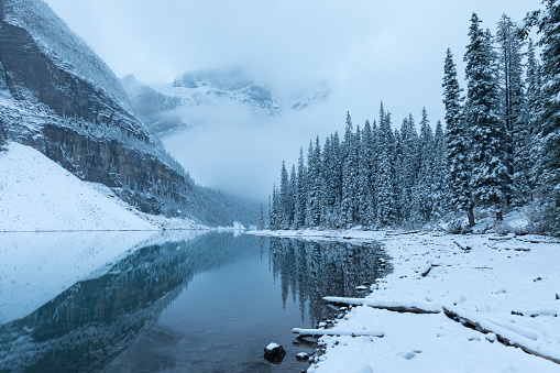 First snow, Morning at Moraine Lake in Banff National Park Alberta Canada Snow-covered winter mountain lake in a winter atmosphere. Beautiful nature background photo. Landscape in the misty weather.