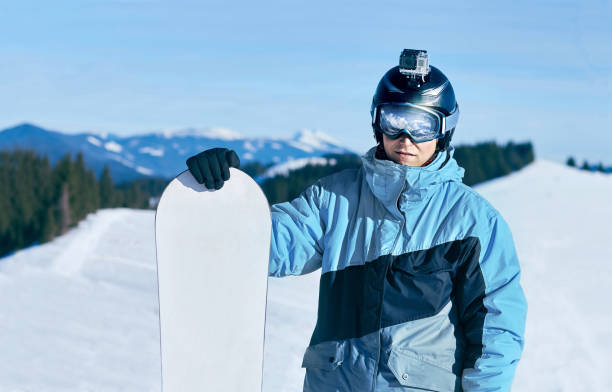 istock Men snowboarder stands with snowboard on mountain backdrop. 1280030347