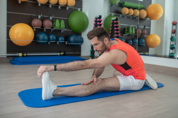 istock Bearded young male bending forward, touching his toes, stretching hamstring 1280031375
