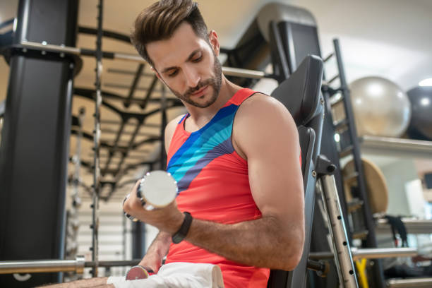 istock Young dark-haired man working on his arms with dumbbells 1280031500