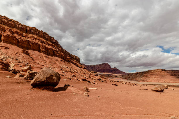 el sol brilla en un lado de la montaña en un día nublado, vermillion cordillera, page, az, ee.uu. - small town america flash fotografías e imágenes de stock