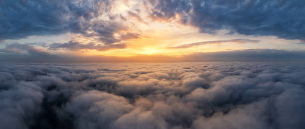 beau ciel dramatique de coucher du soleil au-dessus des nuages moelleux tôt le matin. vue de drone. - flying over photos et images de collection
