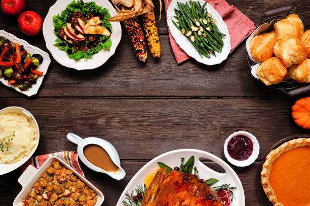 istock Traditional Thanksgiving turkey dinner. Overhead view frame on a dark wood background. 1280031977