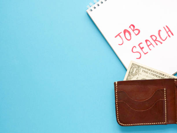 istock notebook with job search phrase, brown wallet, one dollar on blue background. looking for a work, last money, poverty, unemployment, job loss concept. Flat lay, copyspace. 1280034234