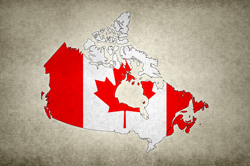 Grunge map of Canada with its flag printed within its border on an old paper.