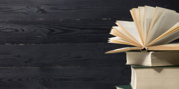 istock Open book, hardback books on wooden table. Back to school. Copy space. 1280037332