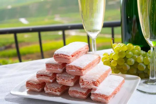 Symbols of Reims rose biscuits and champagne traditional dry sparkling wine and view on green vineyards of Champagne, France