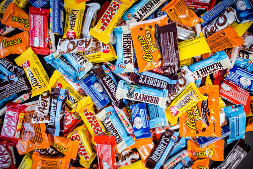 Piles of fun size halloween treats are together shot in a flat lay style